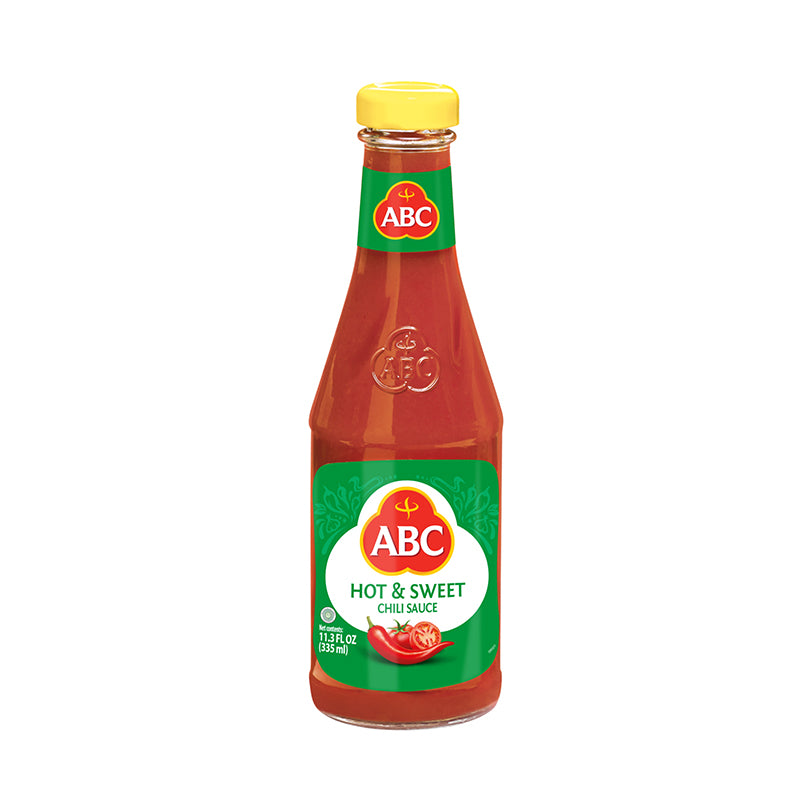 ABC Hot & Sweet Chili sauce in a glass bottle. Tomatoes and fresh chilies are pictured. 