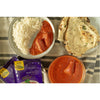 Lifestyle photograph of butter chicken curry with a side of rice and naan. 